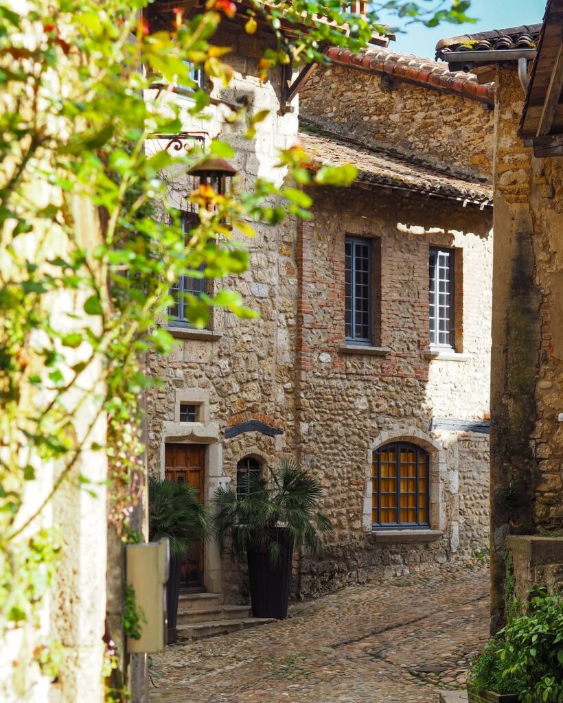 A cozy guesthouse in Perouges, surrounded by greenery and cobblestone streets. Lyon travel guide and weed laws in France.