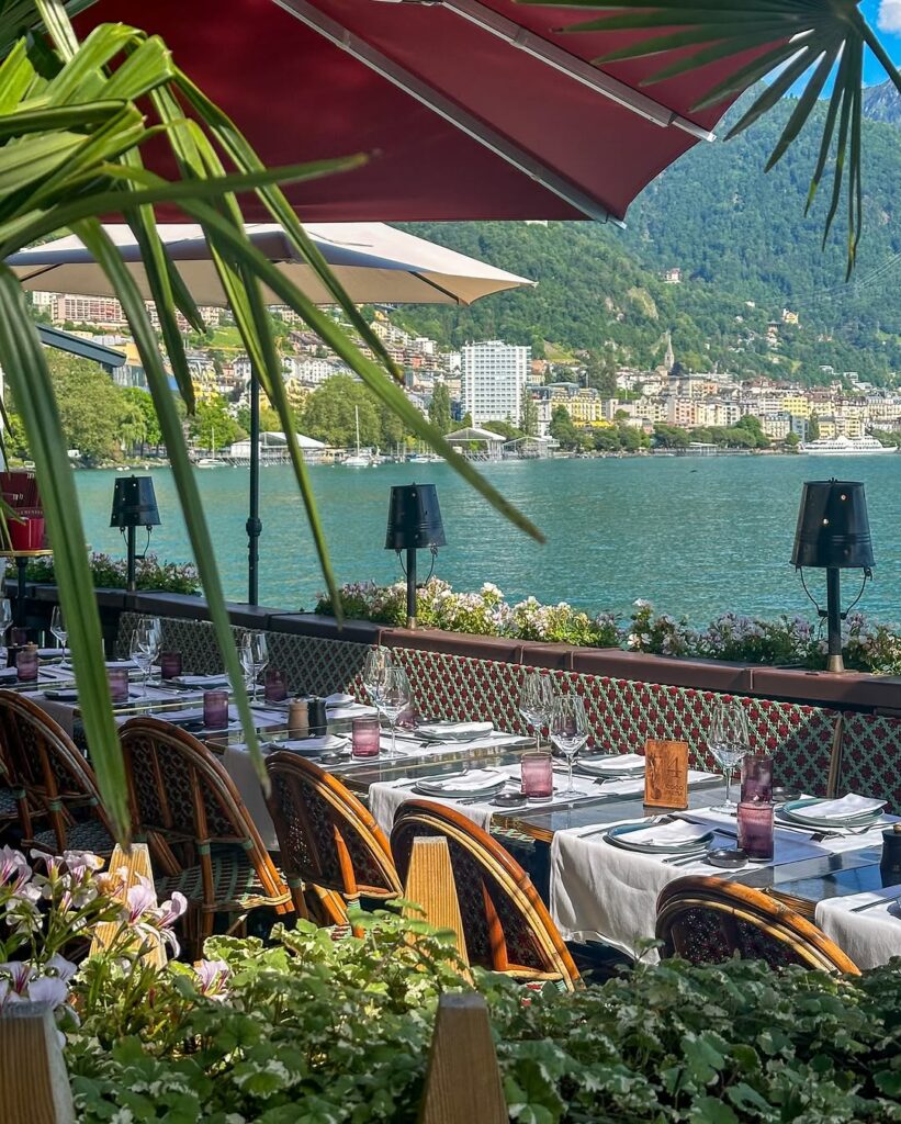 A cozy lakeside inn with flower-filled balconies, overlooking Lake Geneva.