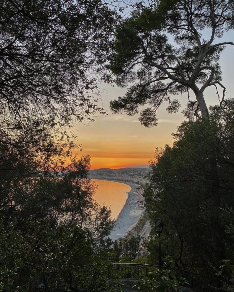 A sunset view of Nice from Castle Hill, with the city and sea bathed in golden light.