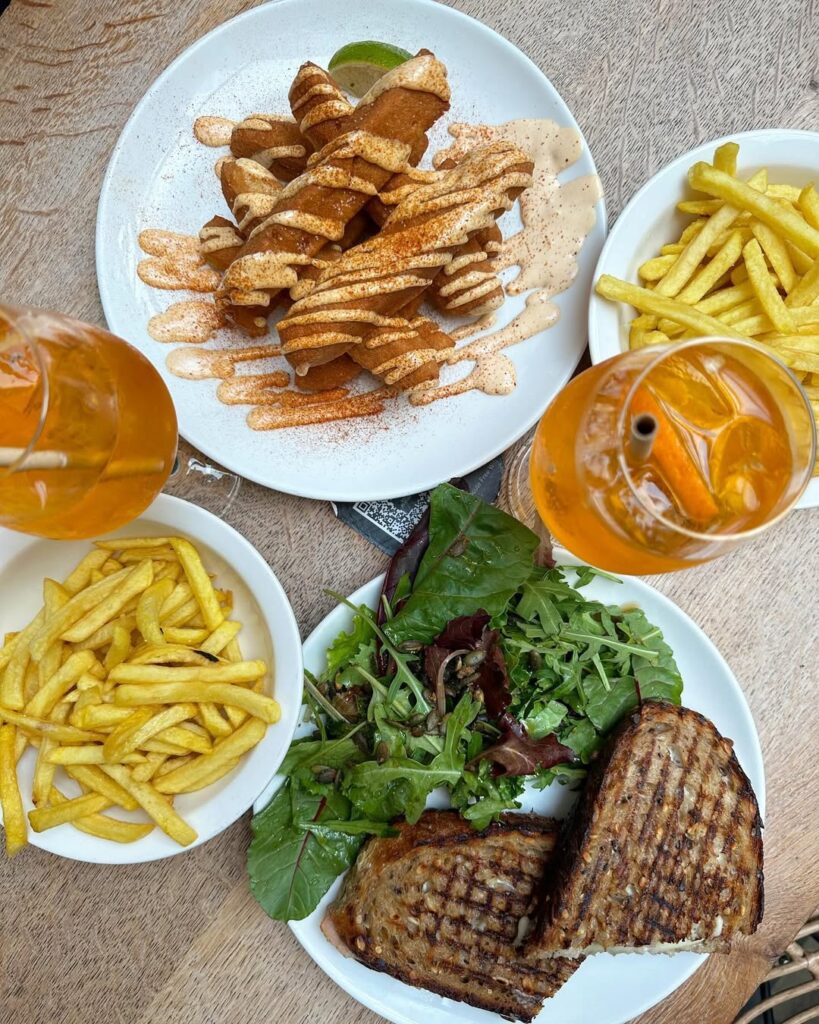 A table set with Quenelles de Brochet, Saucisson Brioche, and a glass of Côtes du Rhône wine.