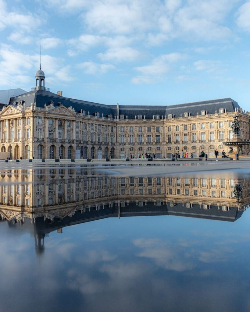 A wide-angle shot of Place de la Bourse and the Miroir d’Eau at sunset.