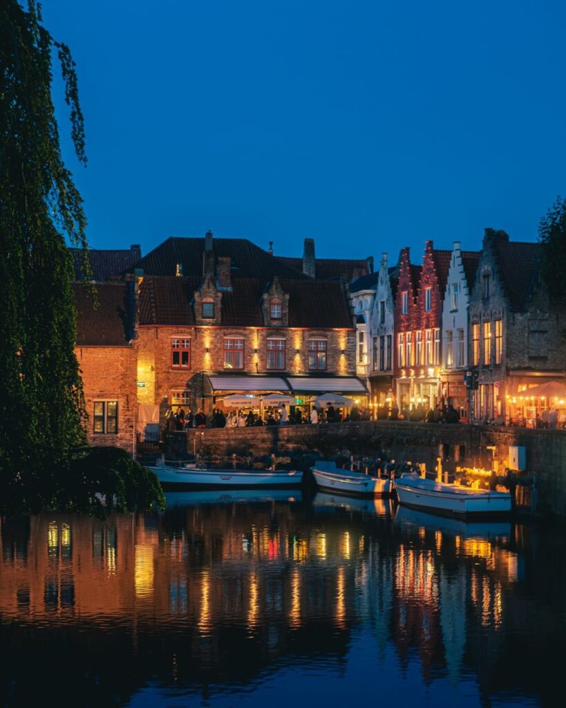 Sunset over Bruges canals with medieval buildings reflected in the water travel guide