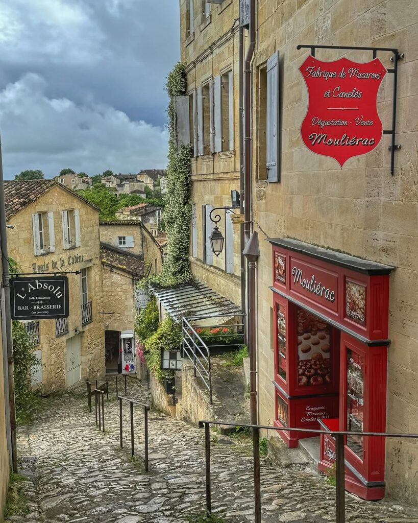 The cobblestone streets of Saint-Émilion, framed by historic buildings and blooming flowers.