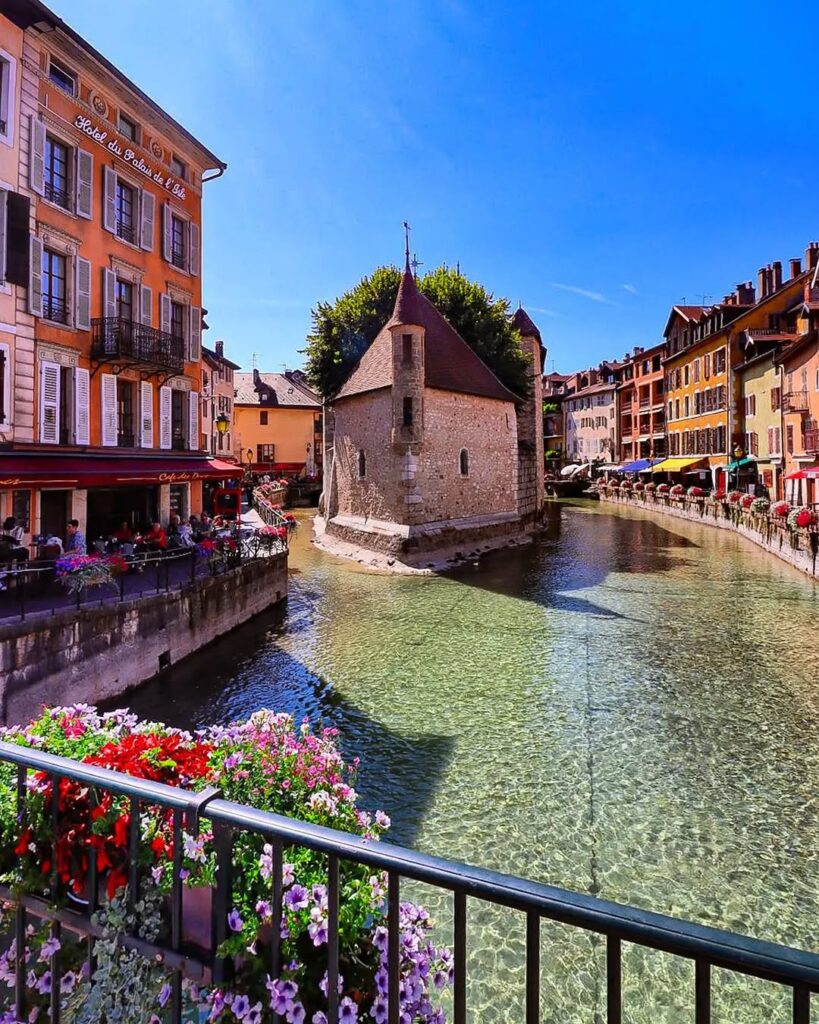 The serene canals of Annecy, framed by the Alps in the distance. Lyon travel guide and weed laws in France.